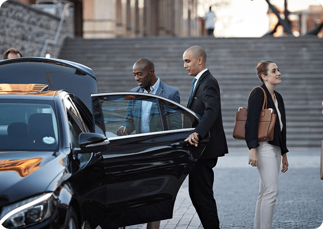 Dependable professional Genius Limo chauffeur beside a black car