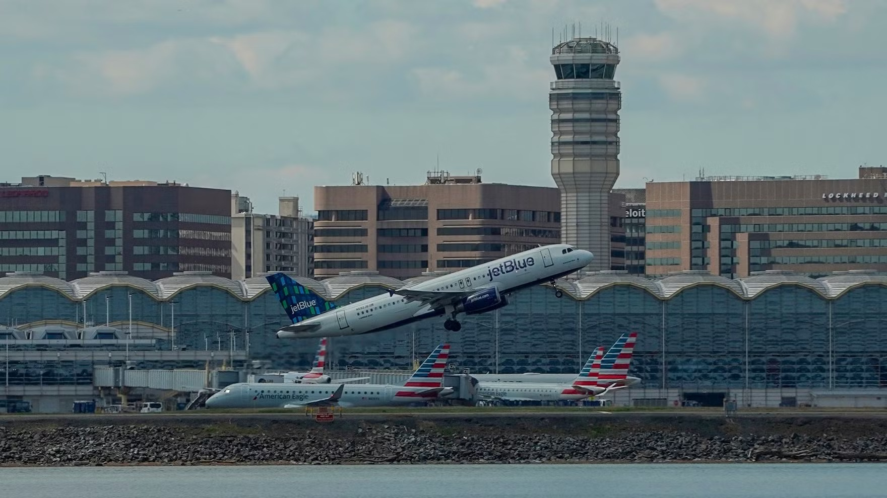 Aircraft departing in front of the terminal and control tower at Ronald Reagan Washington National Airport.